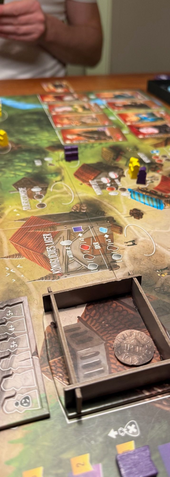 Ein Spieltisch mit einem Brettspiel, Würfeln und Spielfiguren.