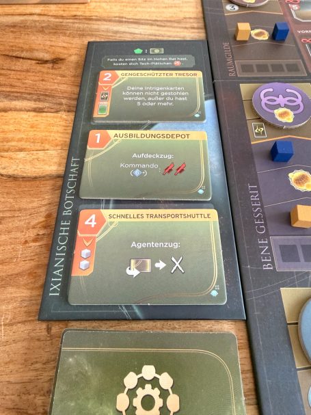 Drei Spielkarten mit Symbolen und Aktionen, die strategische Entscheidungen anzeigen.