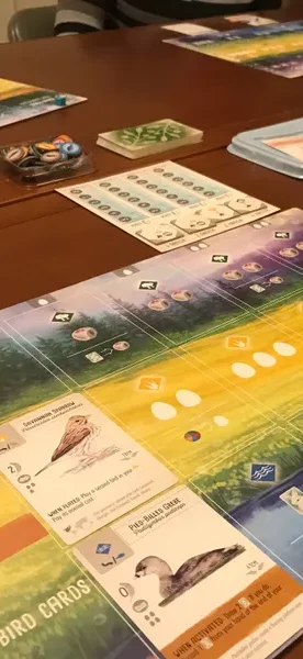 Brettspiel mit verschiedenen Ressourcen, Spielern und Aktionen auf dem Spielbrett.