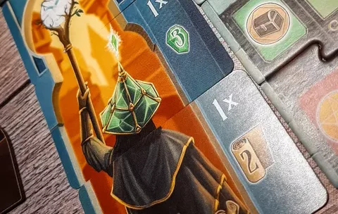 Brettspiel mit bunten Meeples und Ressourcen auf einem Holzspieltisch.