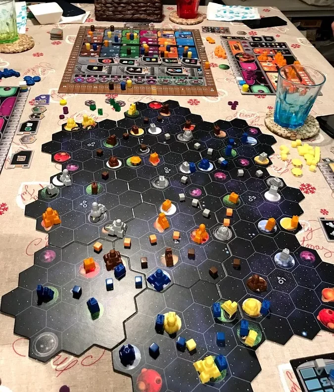 Brettspiel mit bunten Spielfiguren auf einem orangefarbenen Spielbrett.