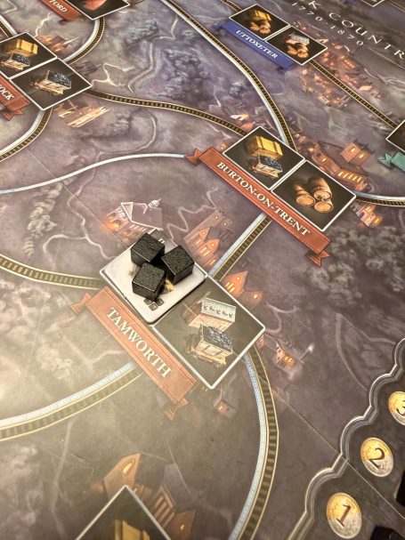 Spielbrett mit Spielfiguren und Karten in einer strategischen Anordnung.