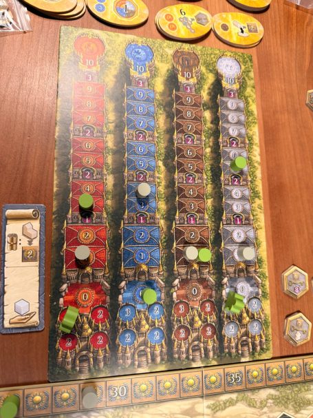 Brettspiel mit farbigen Spielertafeln und Spielfiguren in verschiedenen Farben.