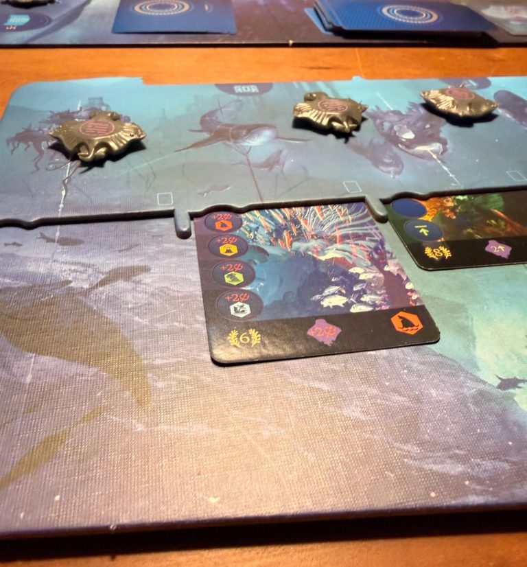 Brettspiel mit bunten Spielfiguren, Ressourcen und Spielkarten.