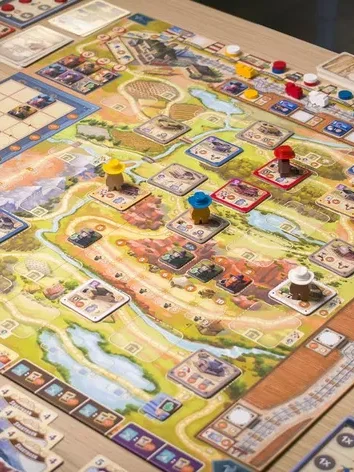 Brettspiel mit bunten Spielfiguren auf einem orangefarbenen Spielbrett.