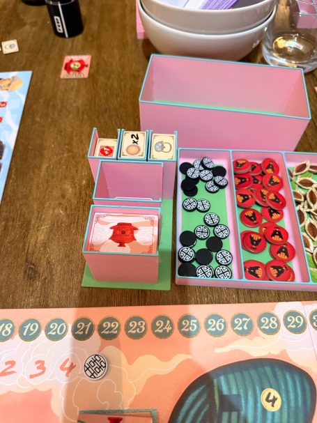 Stapeln von bunten Spielsteinen und Karten auf einem Holztisch.