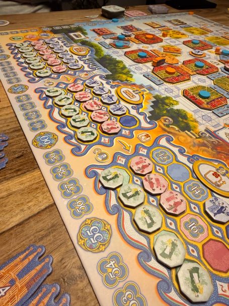 Brettspiel mit bunten Spielsteinen und strategischen Anordnung auf einem Holztablett.