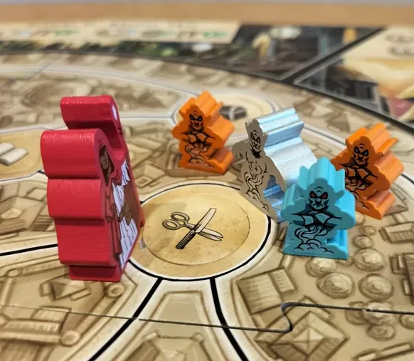 Ein Spielbrett mit Würfeln, Spielsteinen und verschiedenen Spielfeldfeldern.