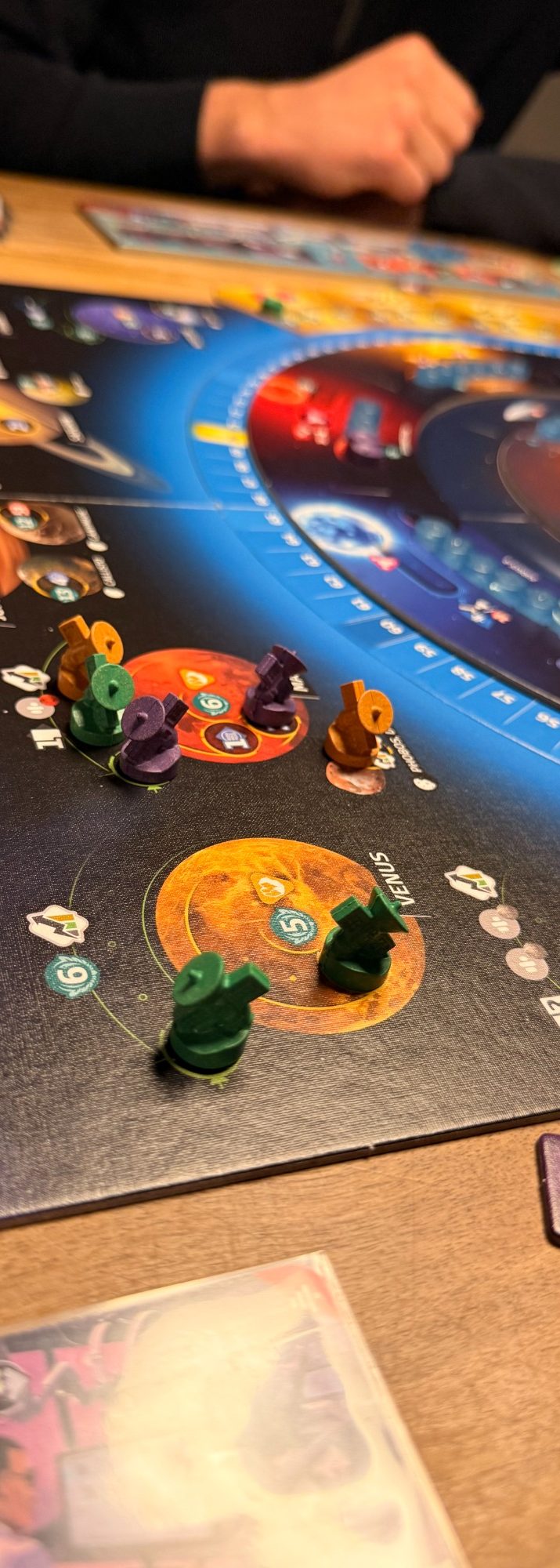 Brettspiel mit bunten Spielfiguren auf einem Weltraum-Themenbrett.