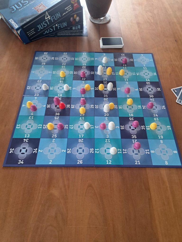 Brettspiel mit bunten Spielfiguren auf einem orangefarbenen Spielbrett.