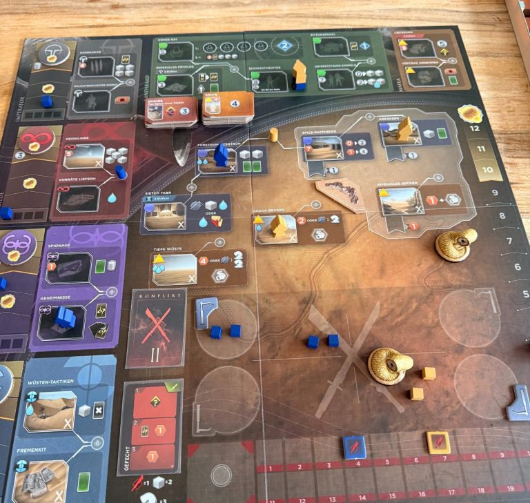 Brettspiel mit verschiedenen Spielfeldern, Ressourcen und Figuren in unterschiedlichen Farben.