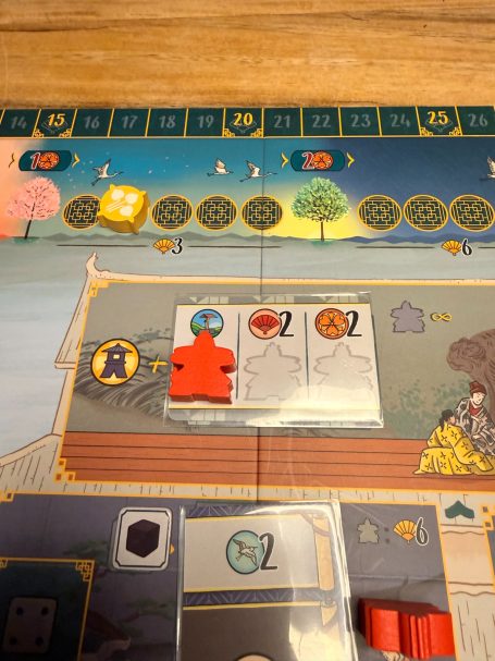 Spielbrett mit orangefarbenem Spielstein und Aktionskarten in einer Brettspielumgebung.