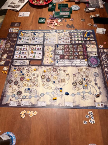 Brettspiel mit vielen Spielsteinen und Karten auf einem Tisch.