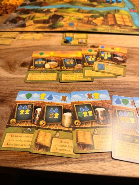 Brettspiel mit Karten für Ressourcenmanagement und strategische Entscheidungen.