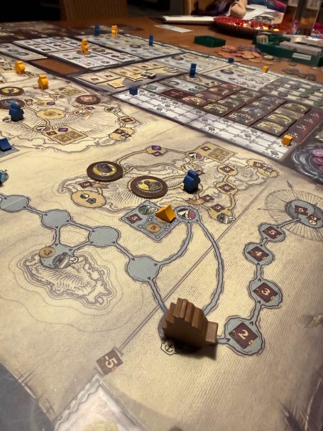 Brettspiel mit mehreren Spielfiguren, Karten und einem detaillierten Spielplan.