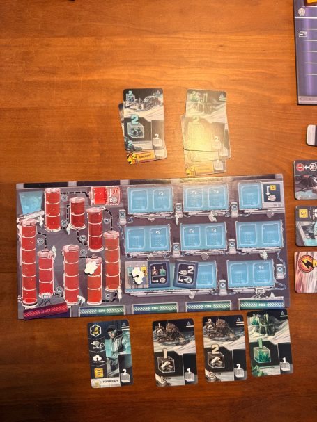 Brettspiel mit Karten und einem Spielbrett in einer strategischen Anordnung auf einem Tisch.