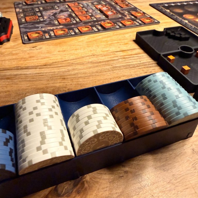 Eine Spielesammlung mit Würfeln in verschiedenen Farben auf einem Holztisch.