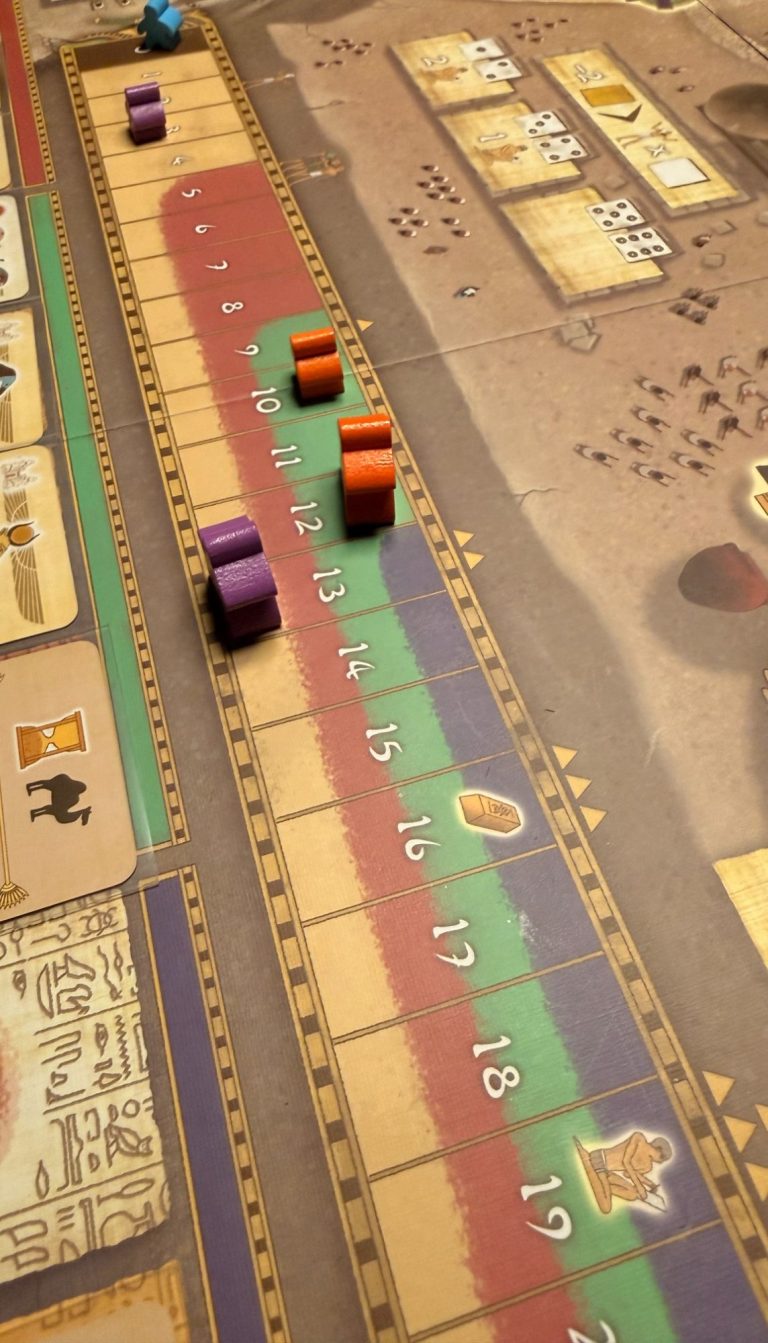 Brettspiel mit bunten Spielsteinen auf einem grafischen Spielfeld.