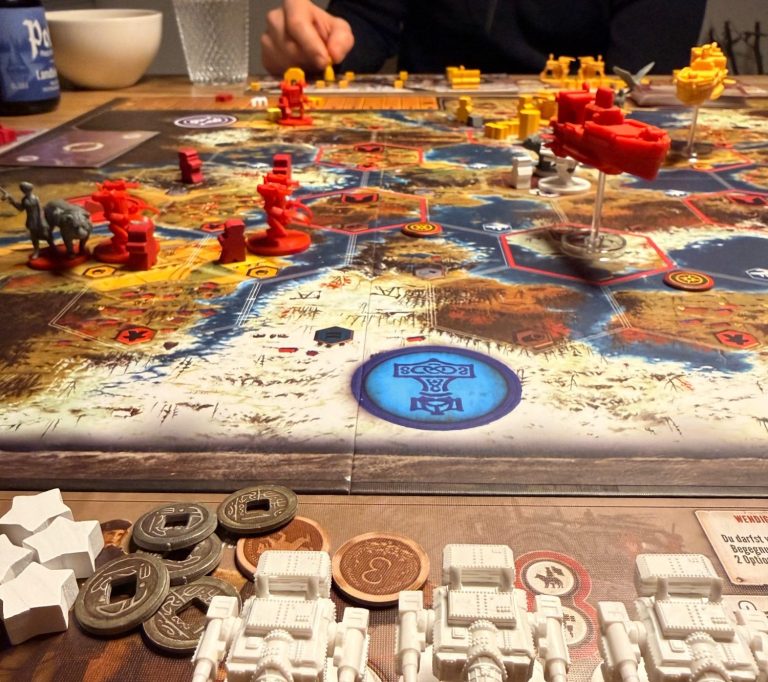 Brettspiel mit Miniaturen und Spielsteinen auf einer detailierten Spielmappe.