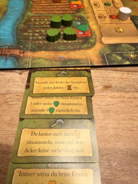 Spielbrett mit Ressourcenmarkern und Aktionskarten in einem Brettspiel.