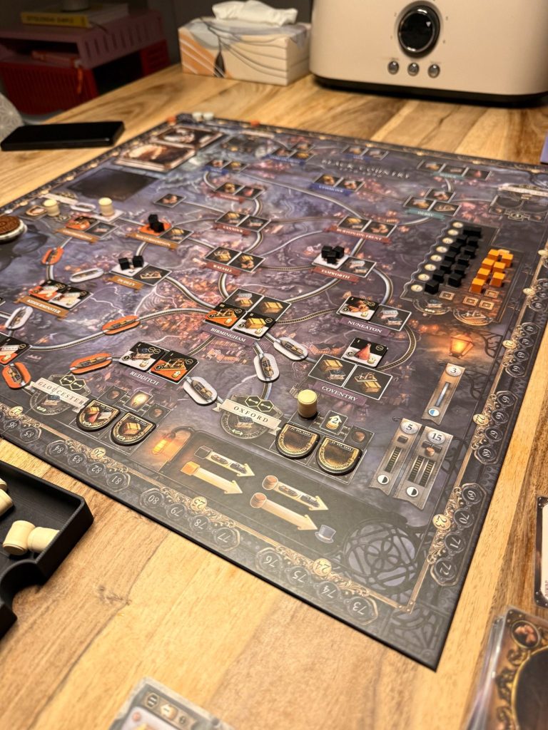 Ein steampunk-inspiriertes Brettspiel mit verschiedenen Spielkomponenten auf einem Tisch.